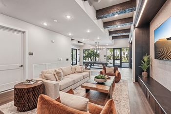 A modern living room with a large couch, a coffee table, and a fireplace
